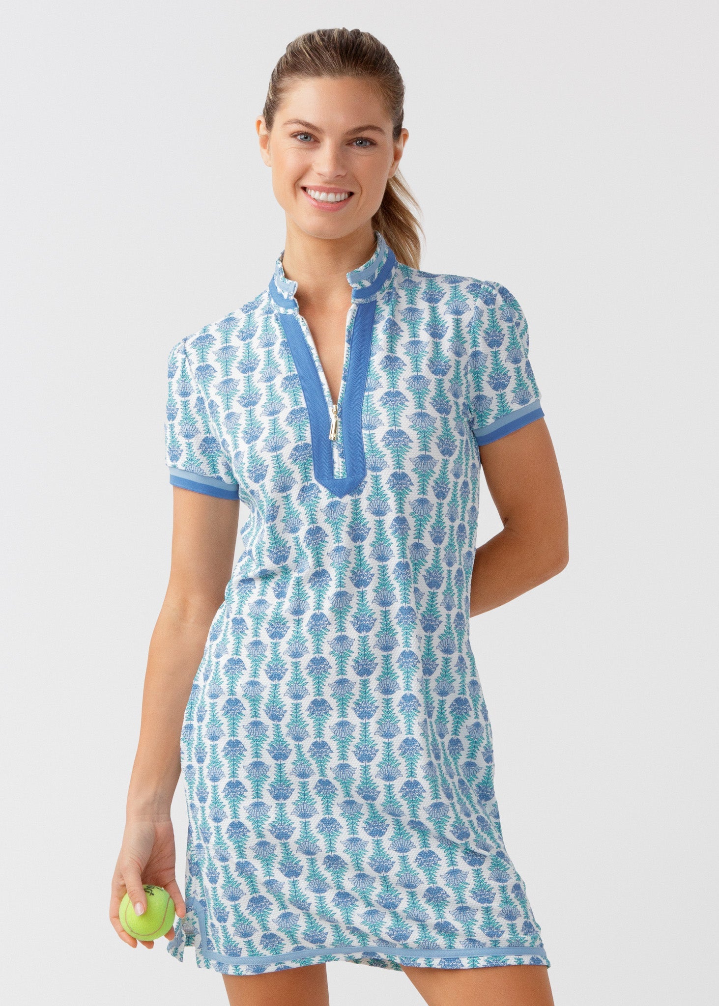 Woman wearing a blue and white patterned dress on a light gray background