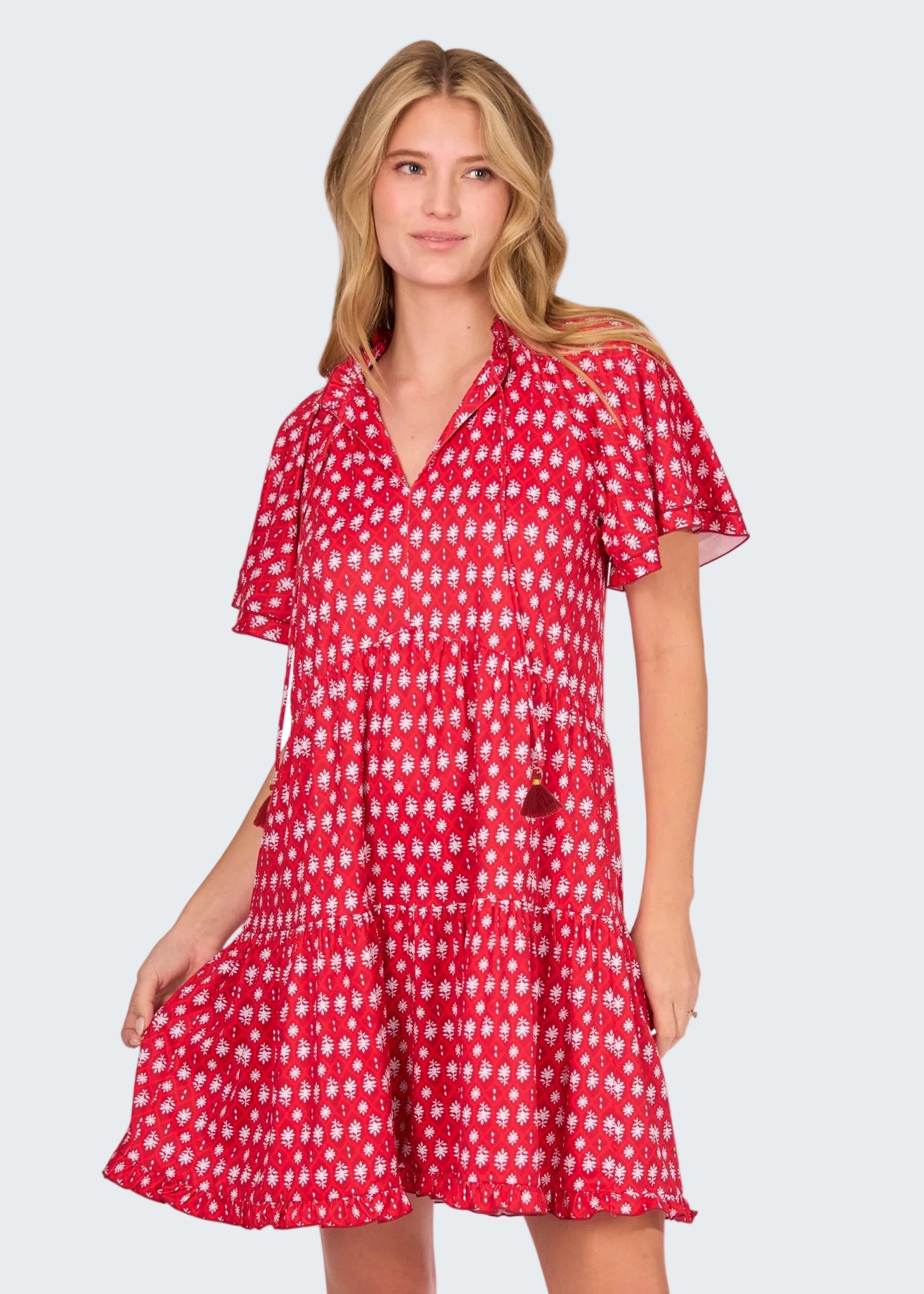Woman wearing a red and white patterned dress on a white background