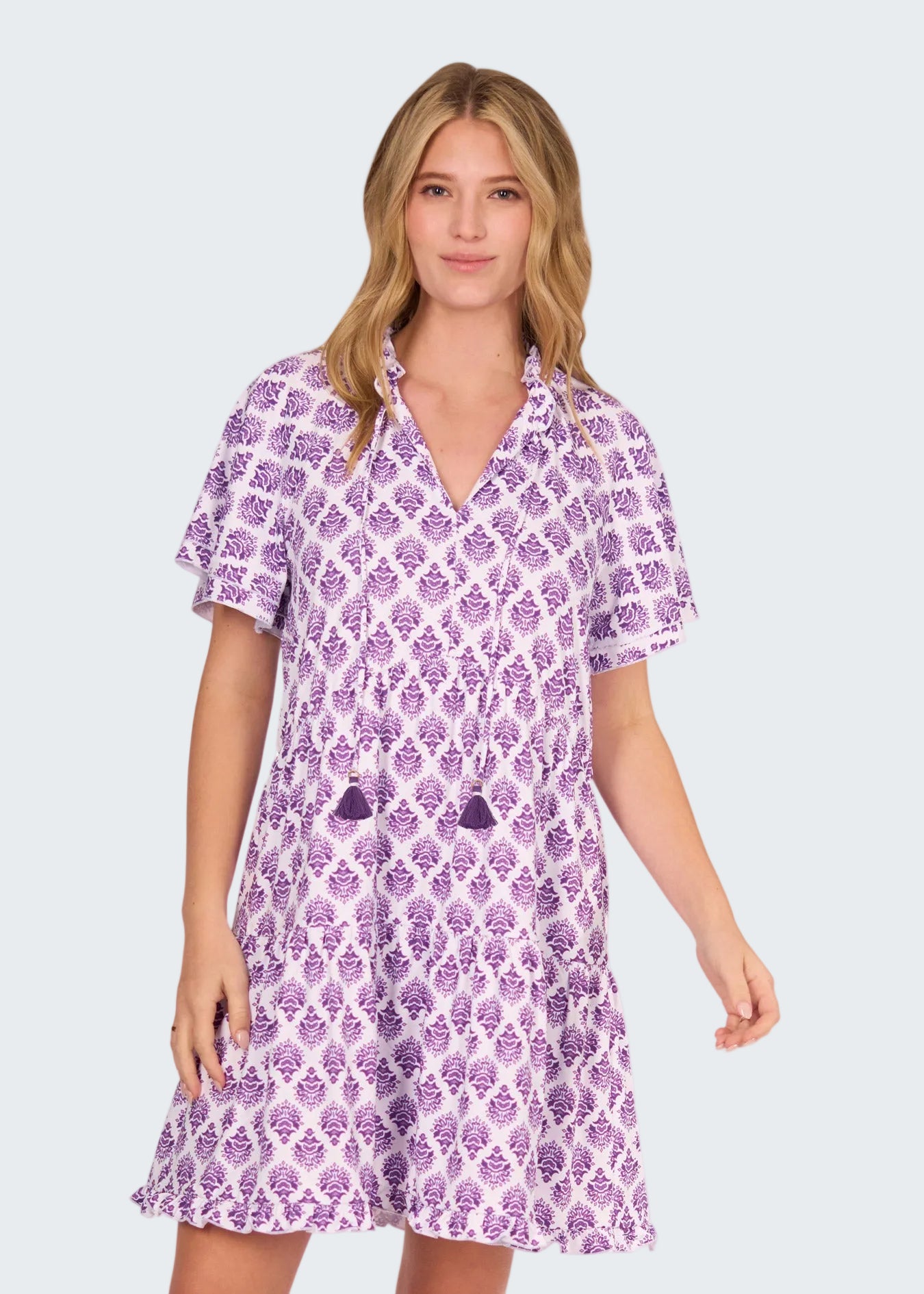 Woman wearing a purple patterned dress on a white background
