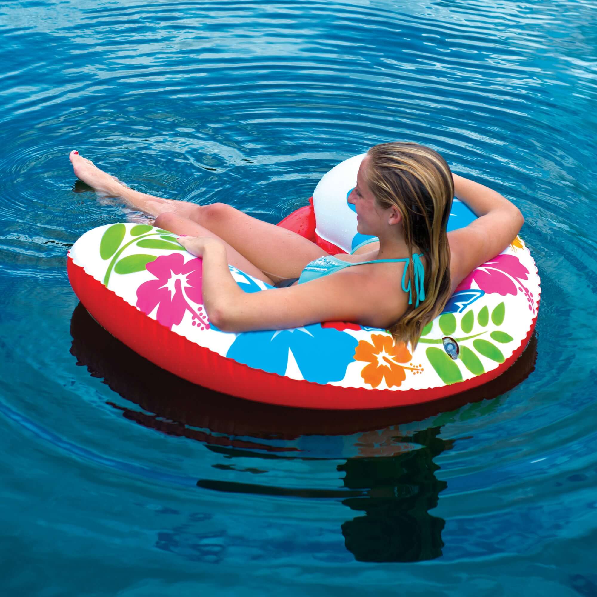 Woman relaxing on a colorful inflatable tube in a pool