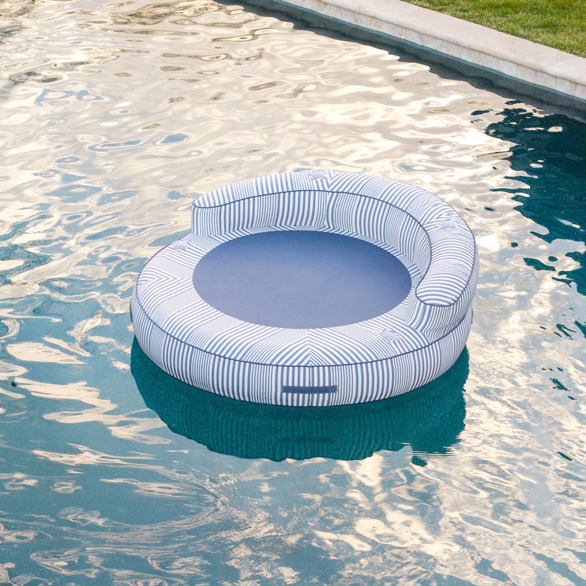 Inflatable pool float with striped pattern floating in a pool