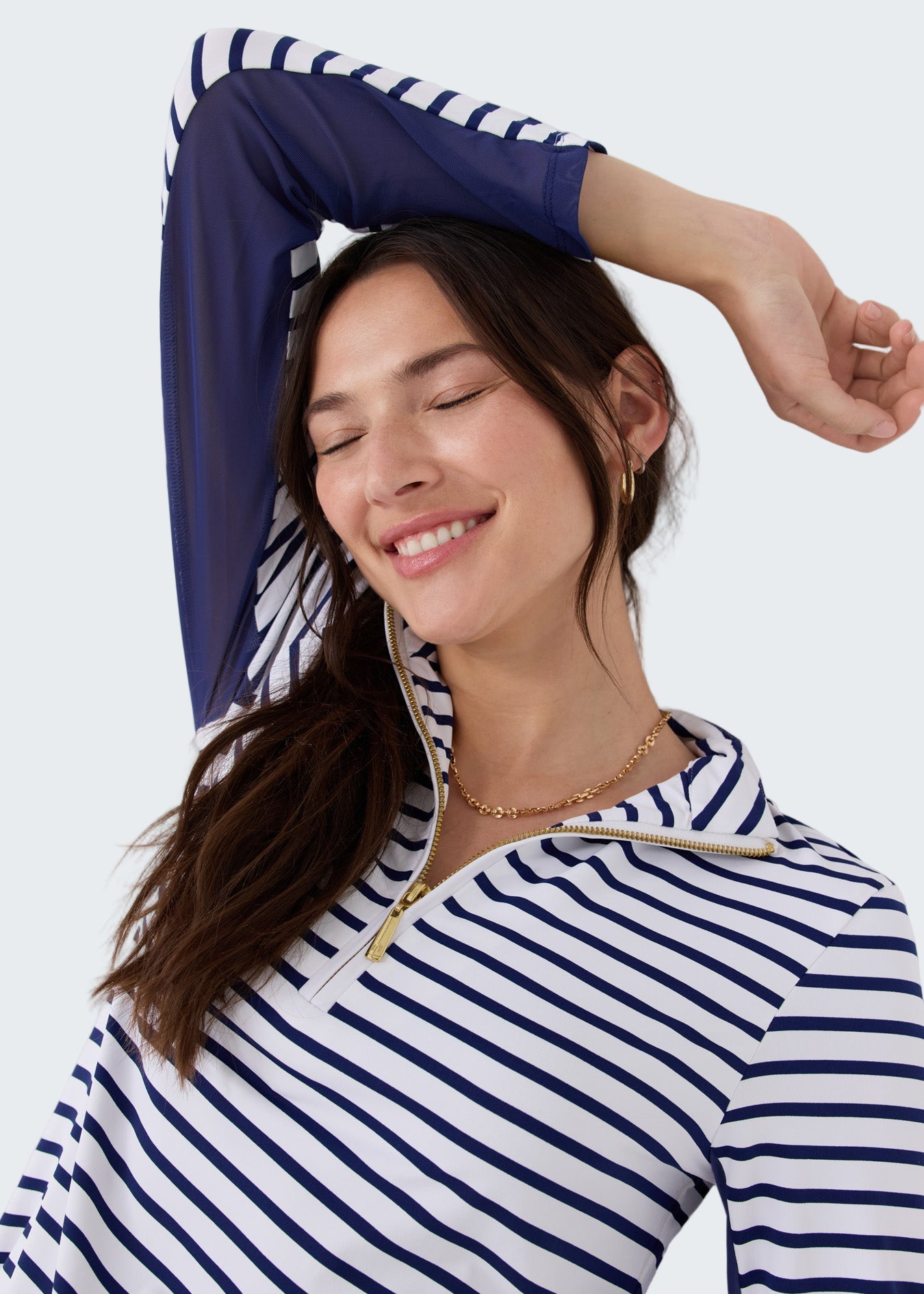 Woman wearing a blue and white striped shirt against a white background