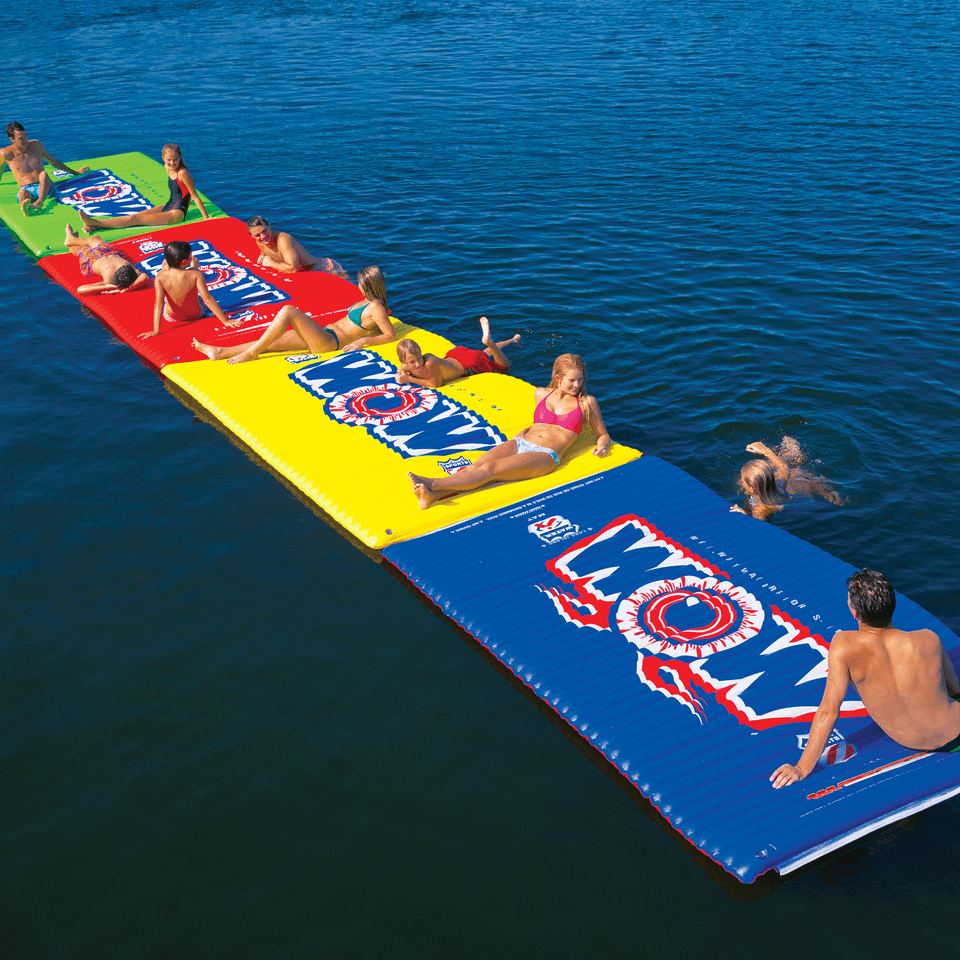 Colorful inflatable water mat with people on a body of water