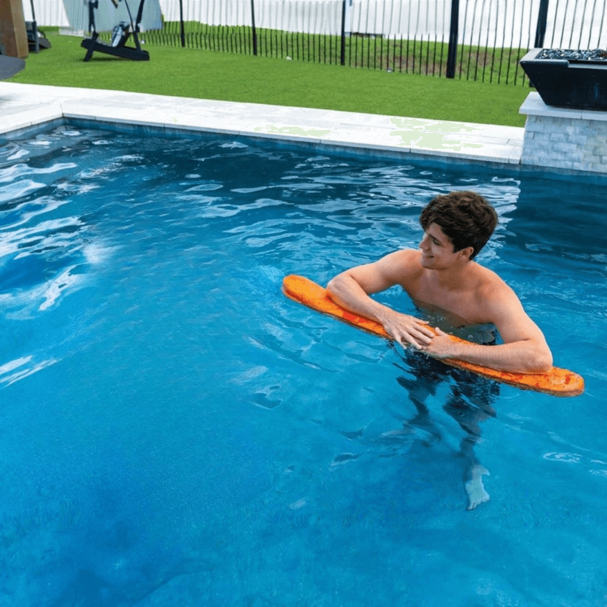 Person using an orange浮板 in a pool