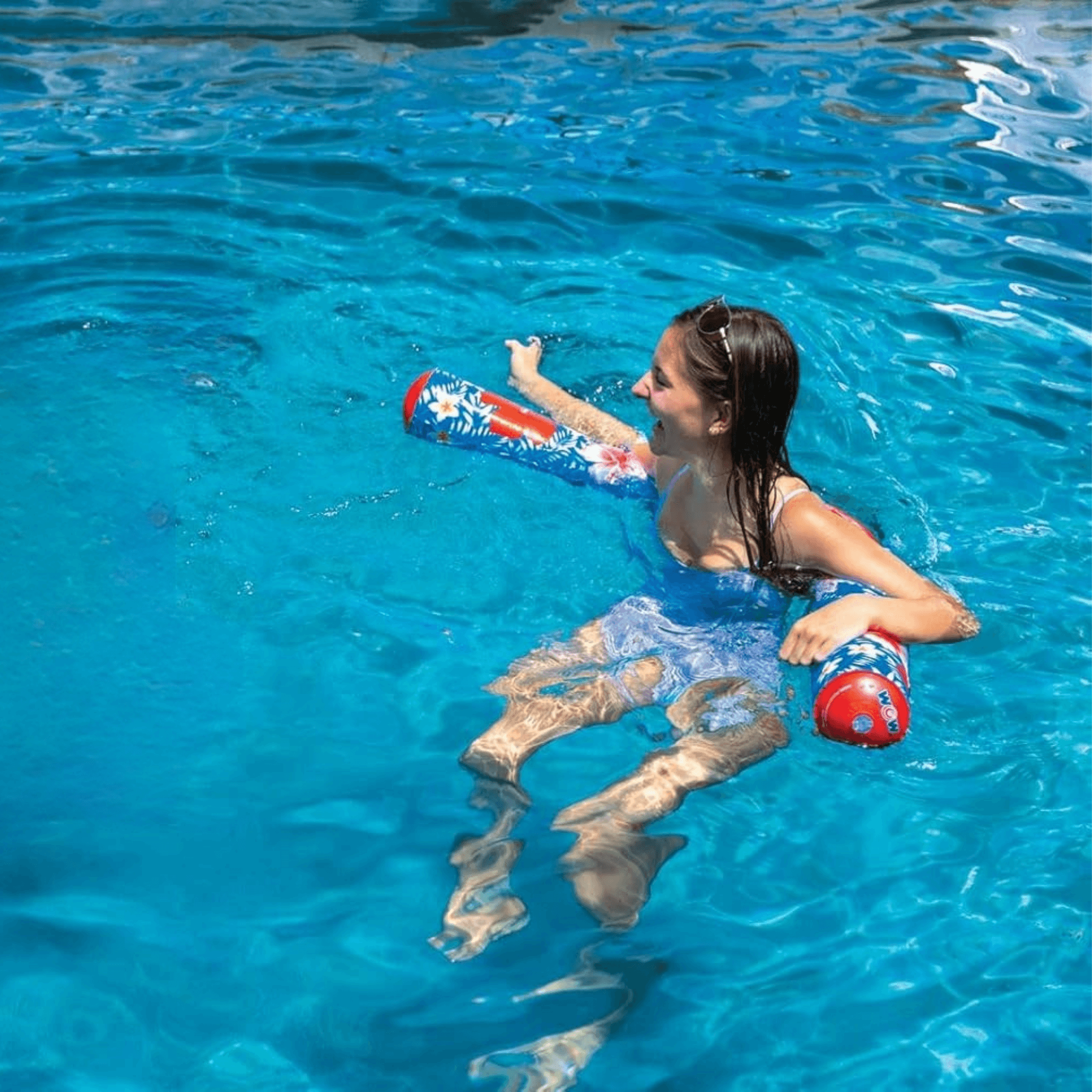 Person floating in a pool with a colorful inflatable tube
