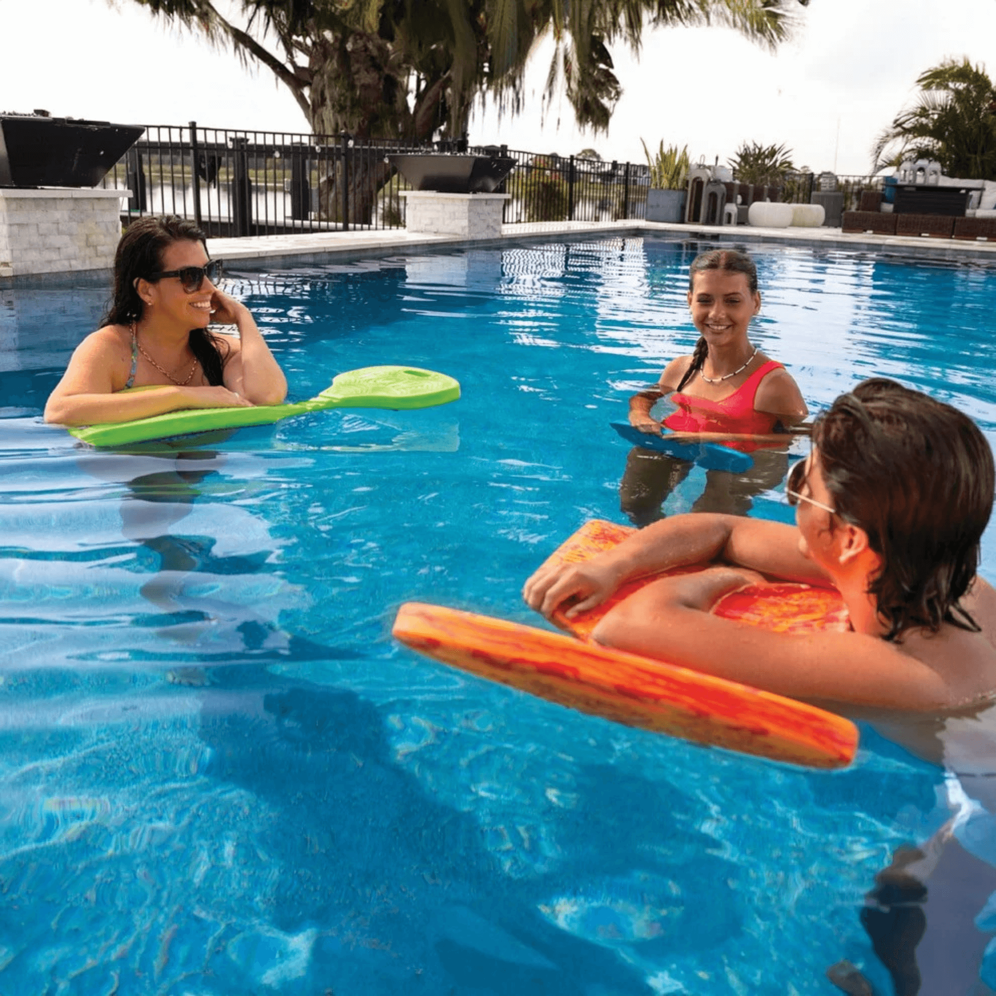 Three people in a pool with colorful floaties