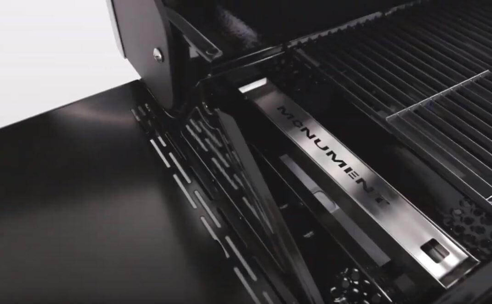 Close-up of a black grill with 'Ravin' branding on a white background