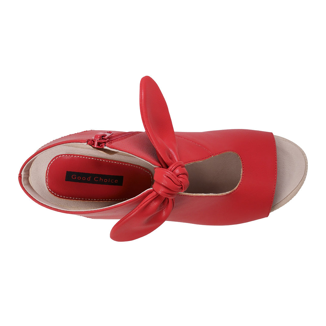 Red sandal with a knot detail on a white background