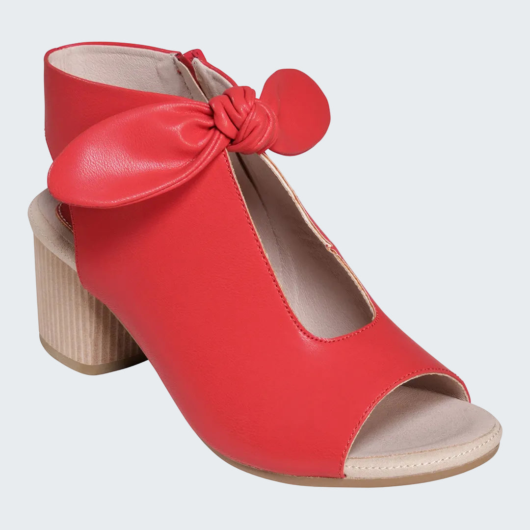 Red high-heeled shoe with a bow on a white background
