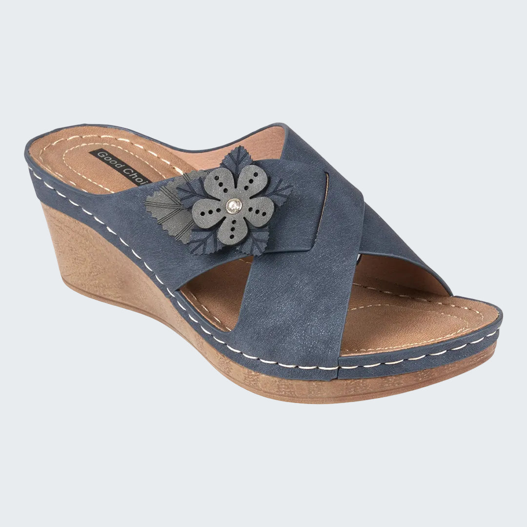 Blue wedge sandal with a flower detail on a white background