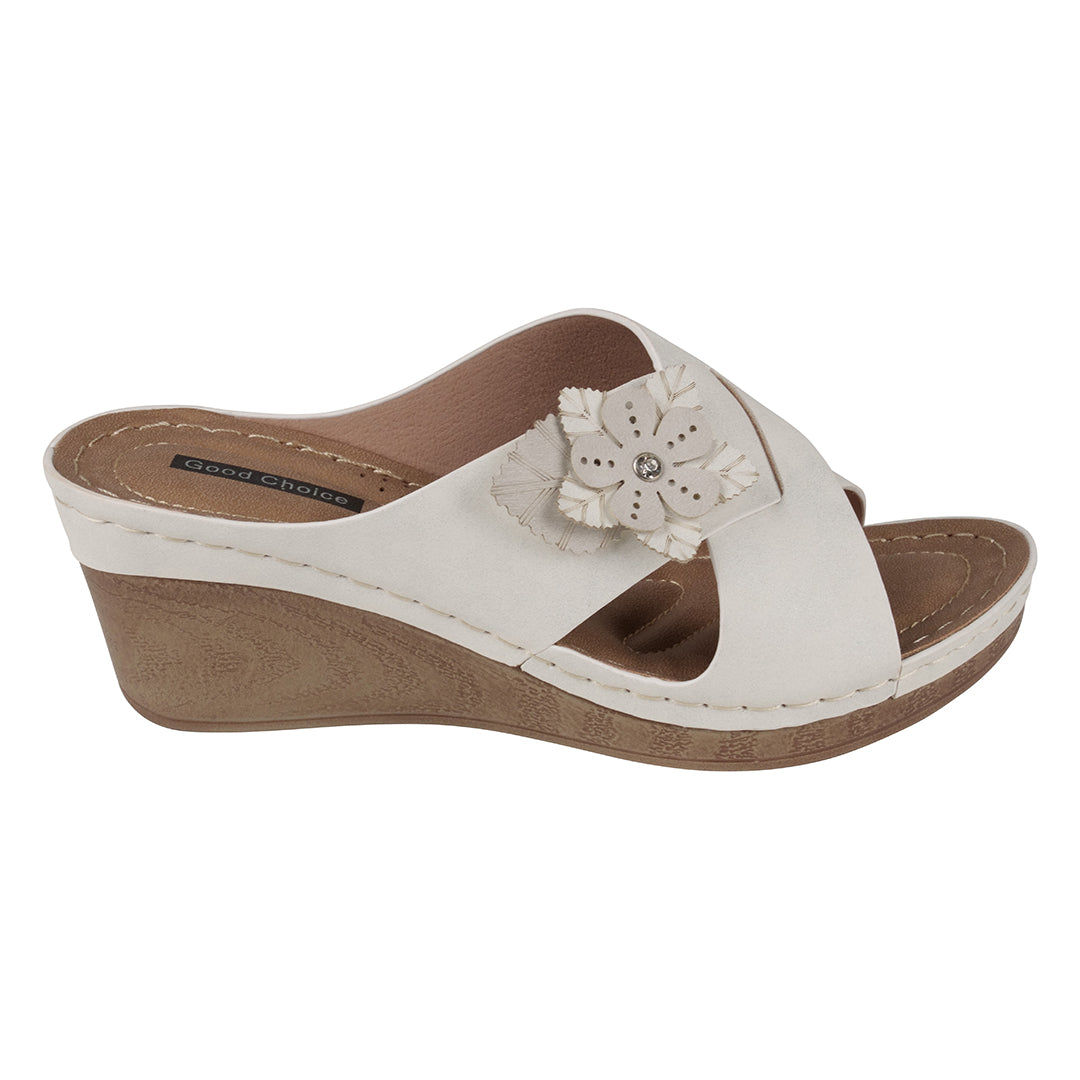 White wedge sandal with a flower detail on a white background