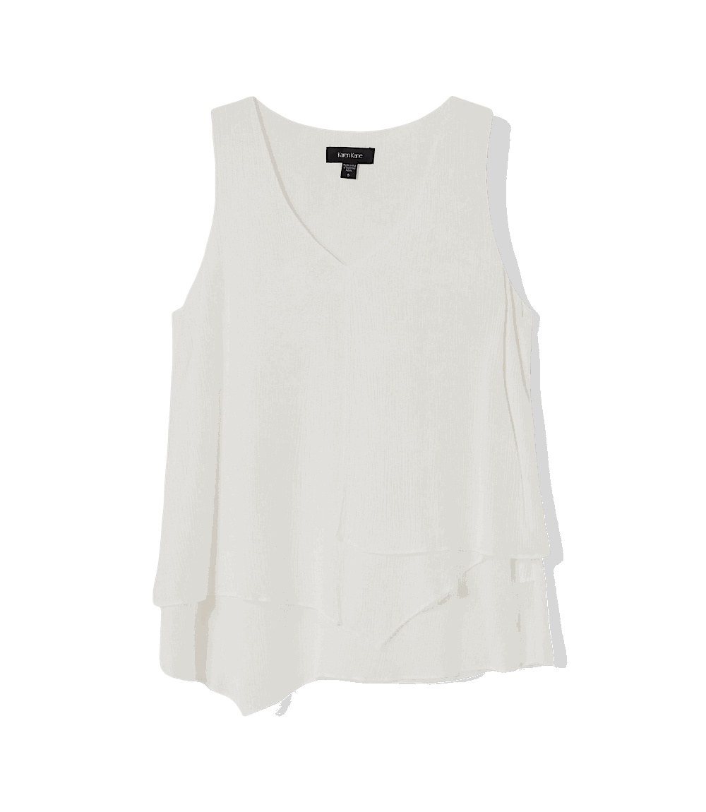 White sleeveless top with a brand label on a black background