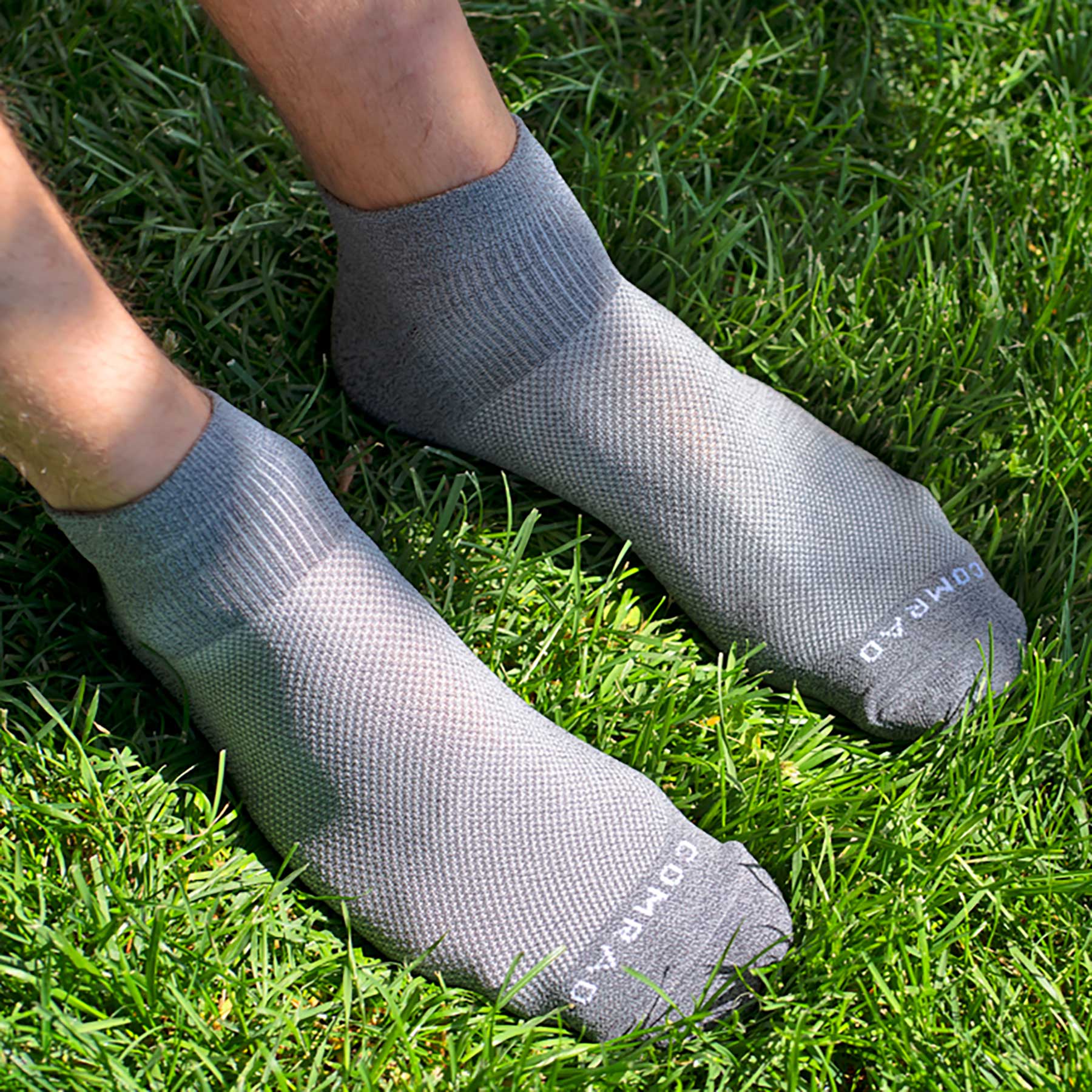 Gray socks on feet standing on grass