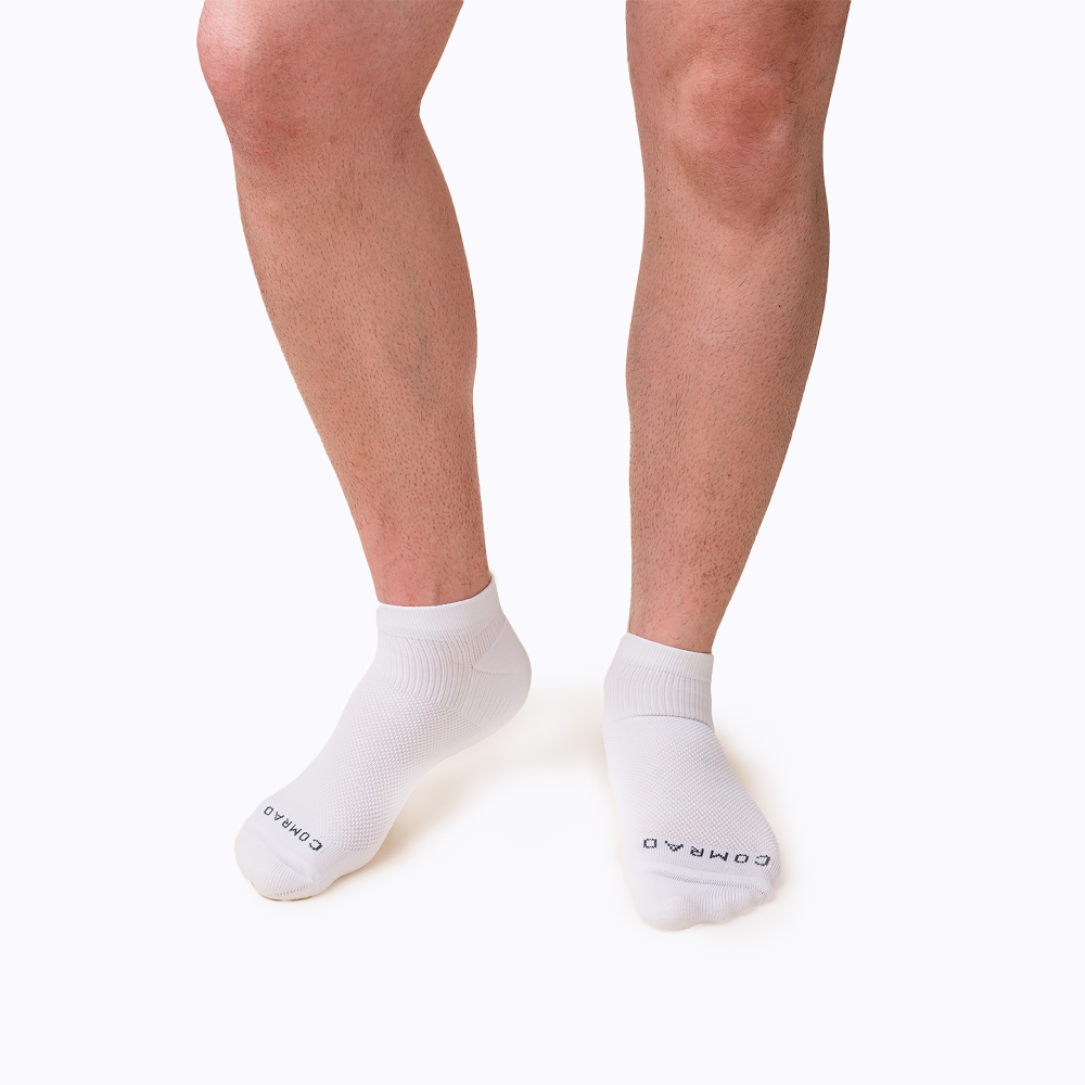 White socks worn by a person on a white background