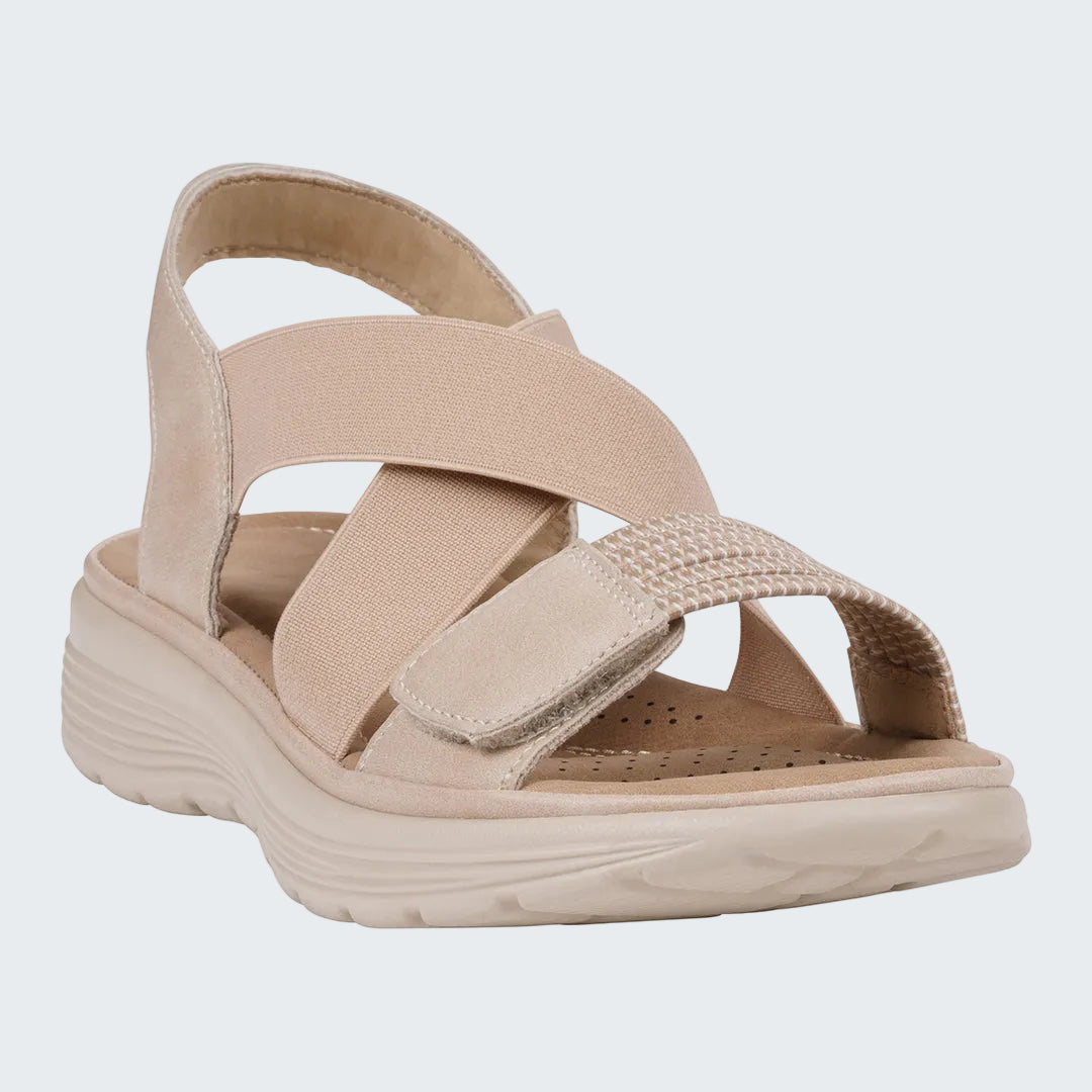 Beige sandal with criss-cross straps on a white background