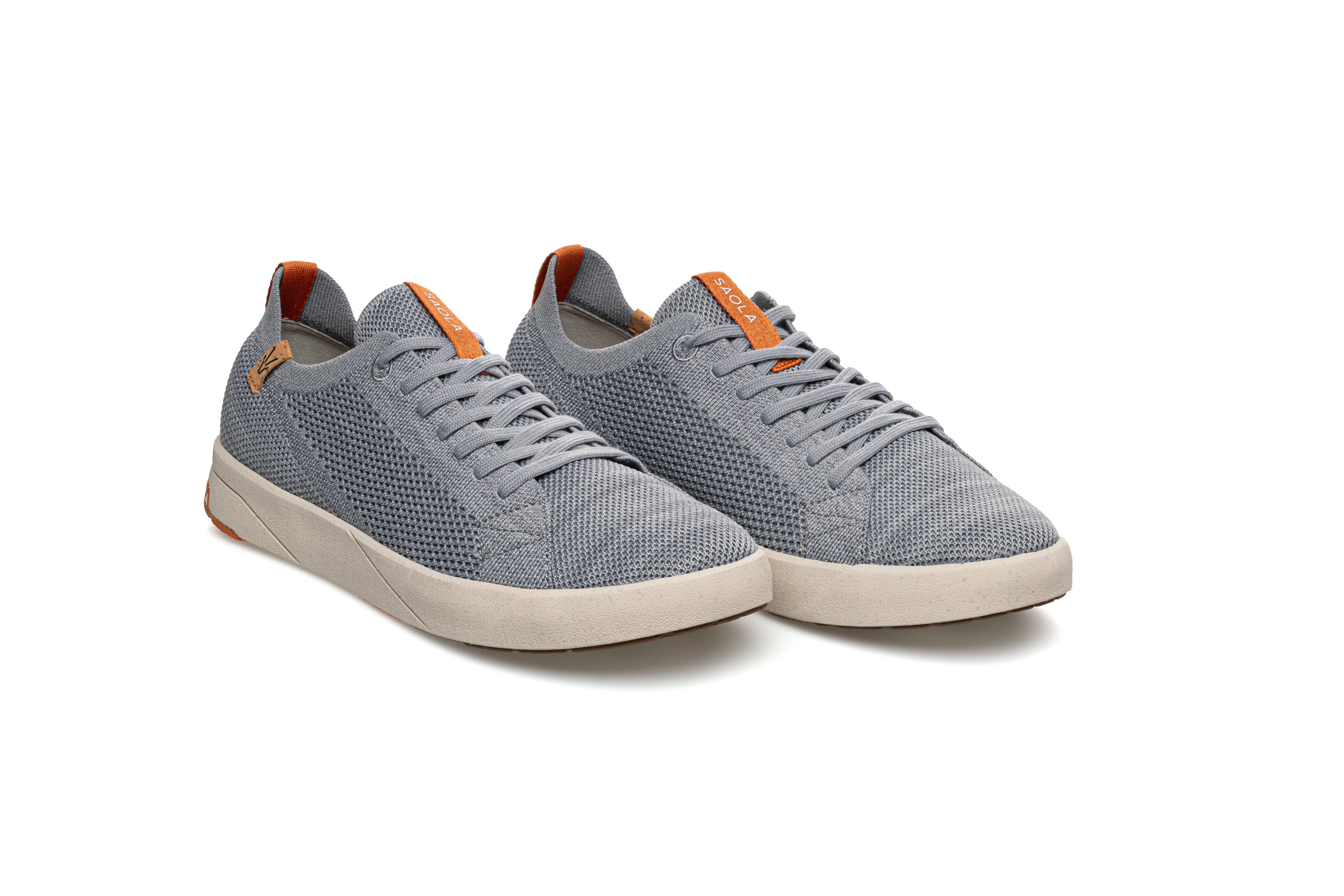 Pair of gray sneakers with orange accents on a white background