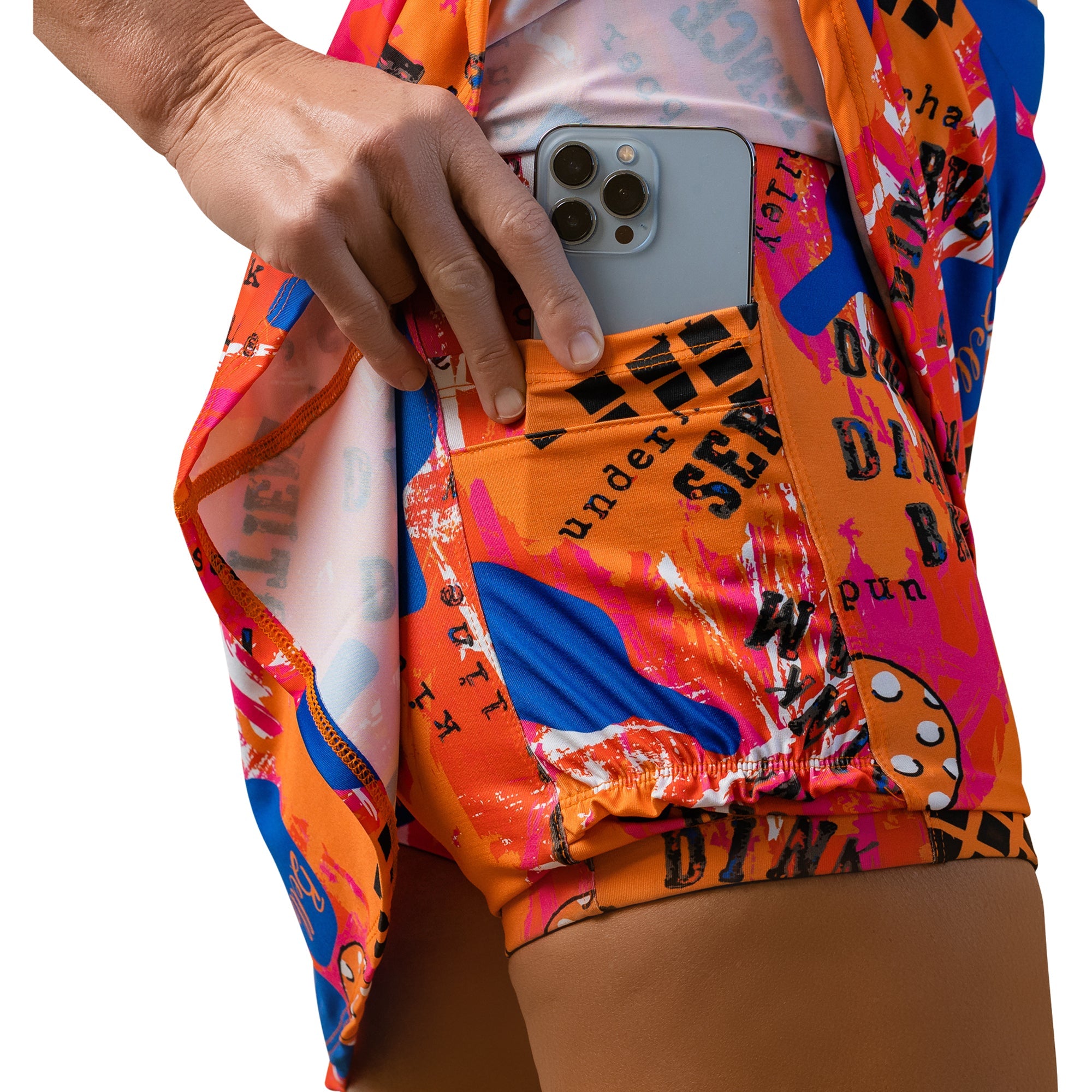 Person wearing colorful shorts with text and patterns, holding a phone.