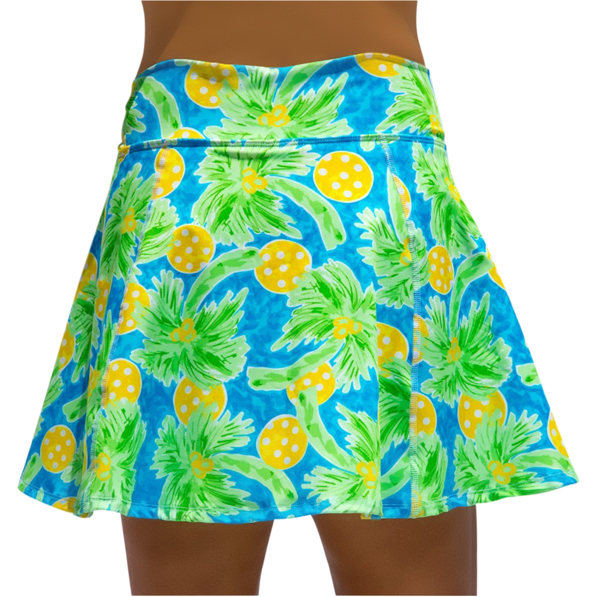 Tropical patterned skirt with green leaves and yellow circles on a blue background