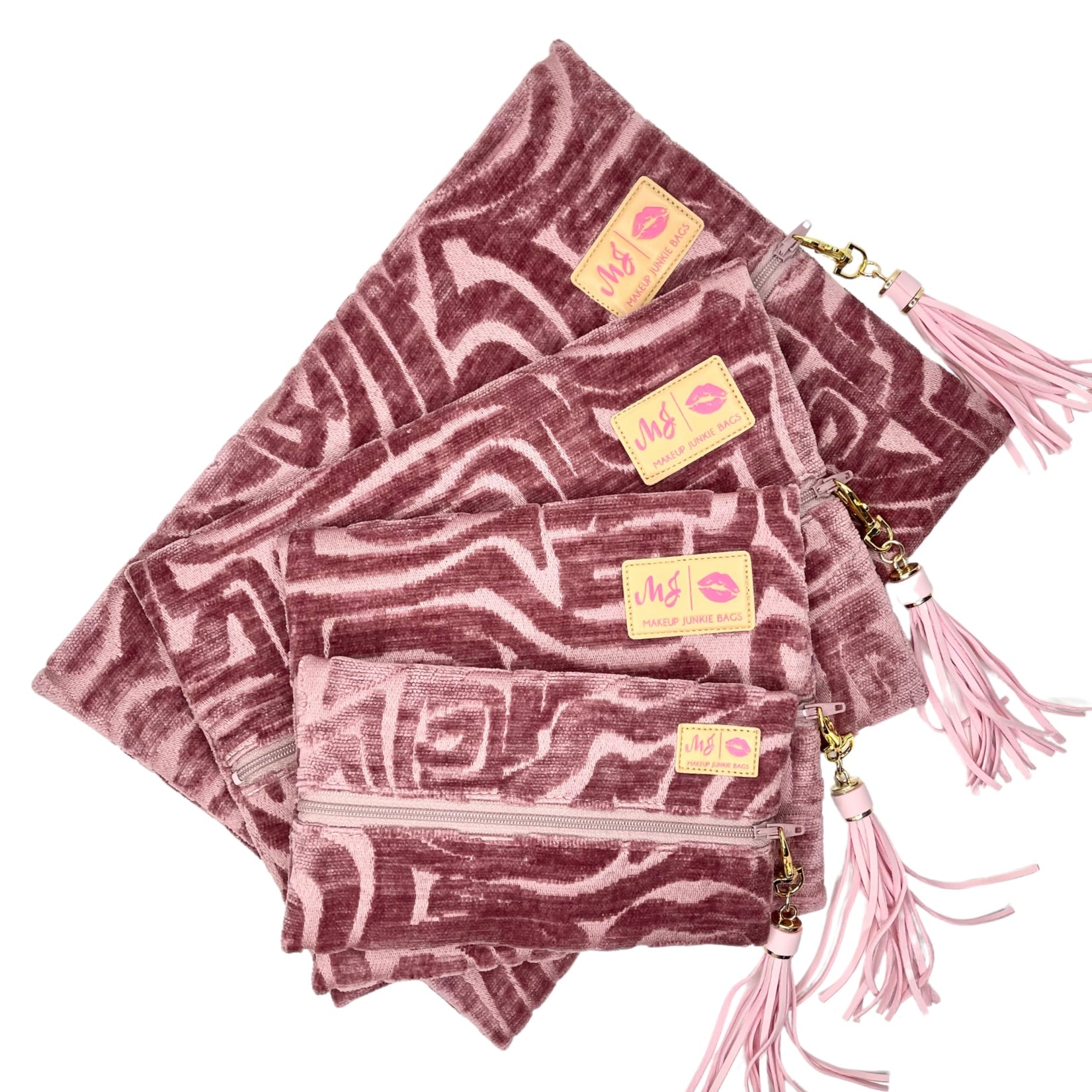 Set of pink patterned bags with tassels and visible brand logo on a white background