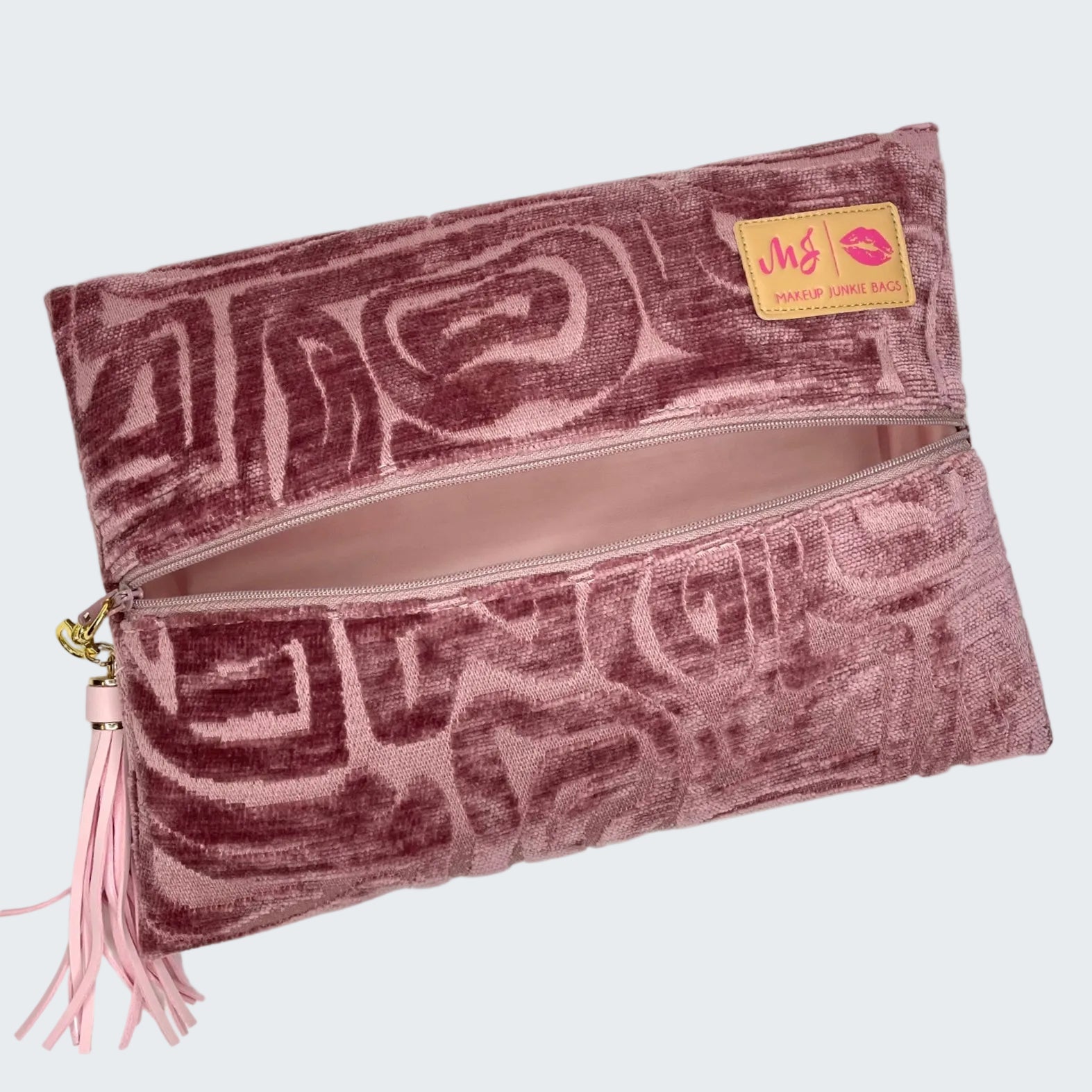 Pink patterned clutch bag with a visible brand label on a white background