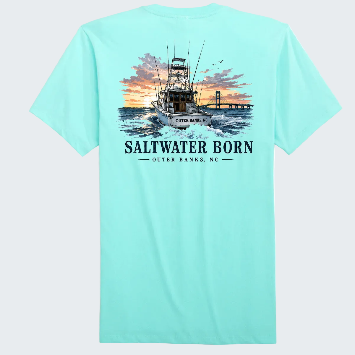 A light aqua blue short-sleeve t-shirt shown from the back, featuring a large graphic print of a fishing boat on the water at sunset with the text 'SALTWATER BORN' and 'OUTER BANKS, NC'.