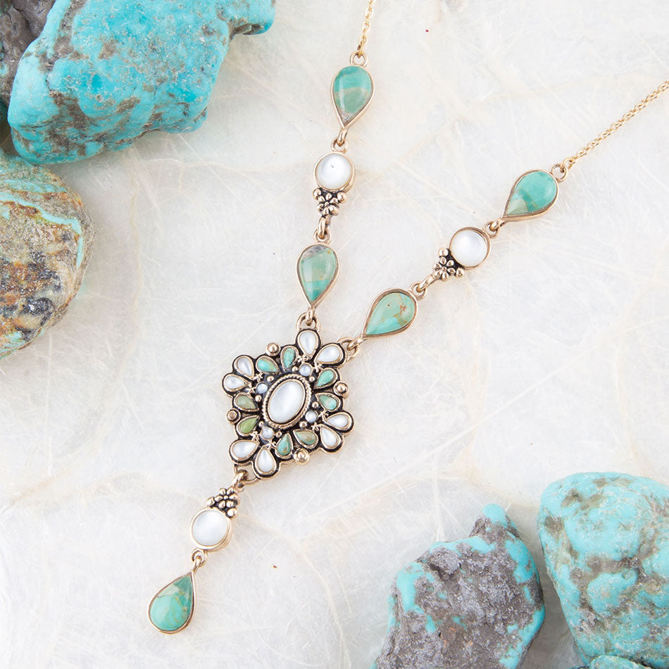 Necklace with turquoise and pearl stones on a white surface with turquoise stones.