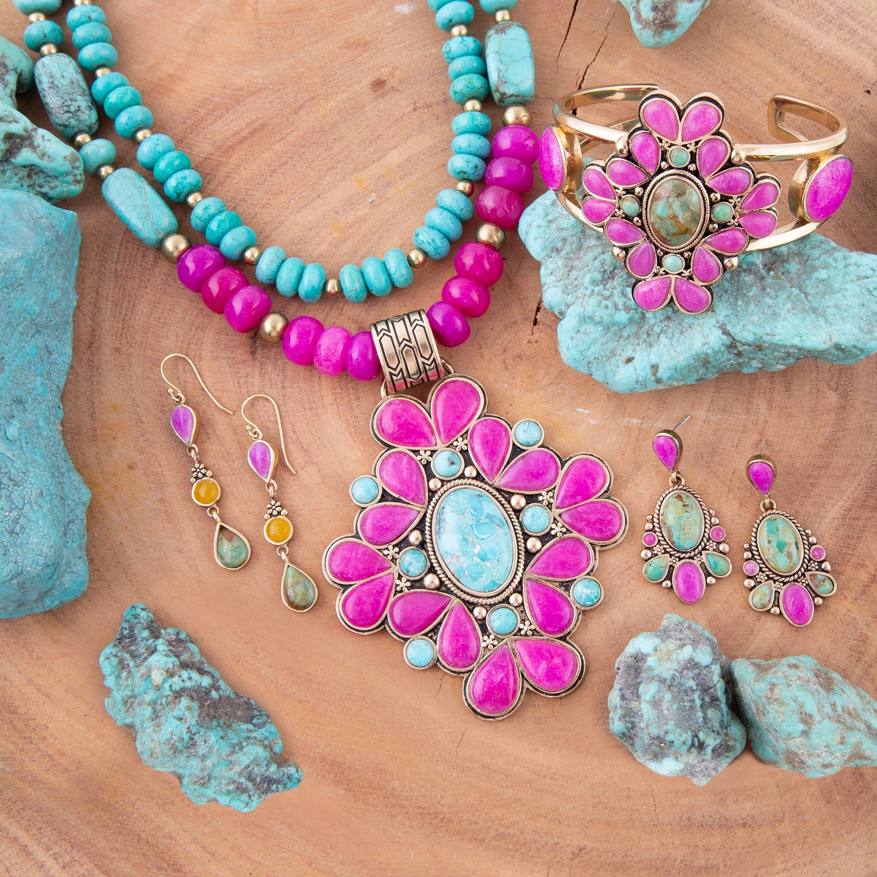 Jewelry set with pink and turquoise stones on a wooden surface with turquoise stones.