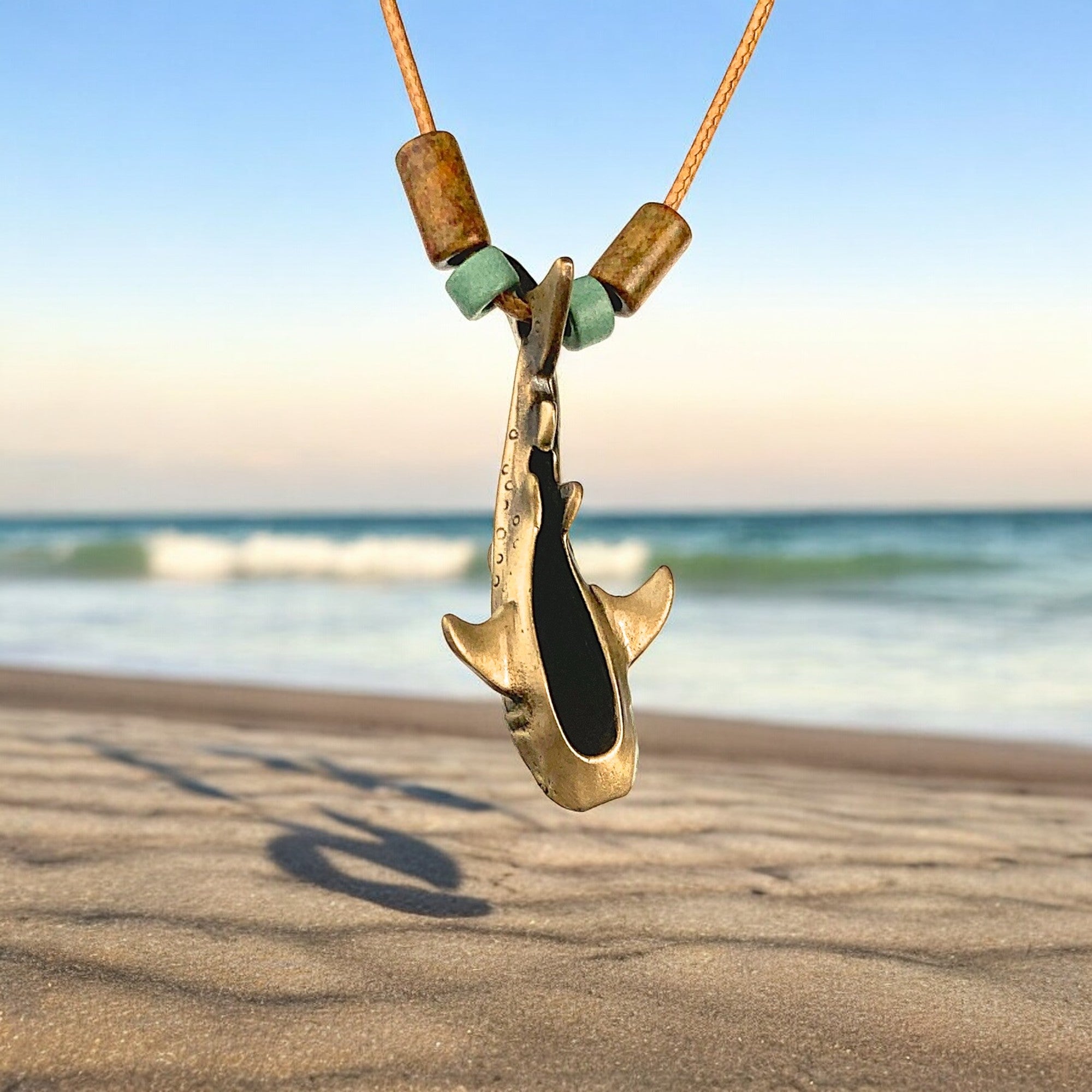 Shark necklace with wooden beads on a beach