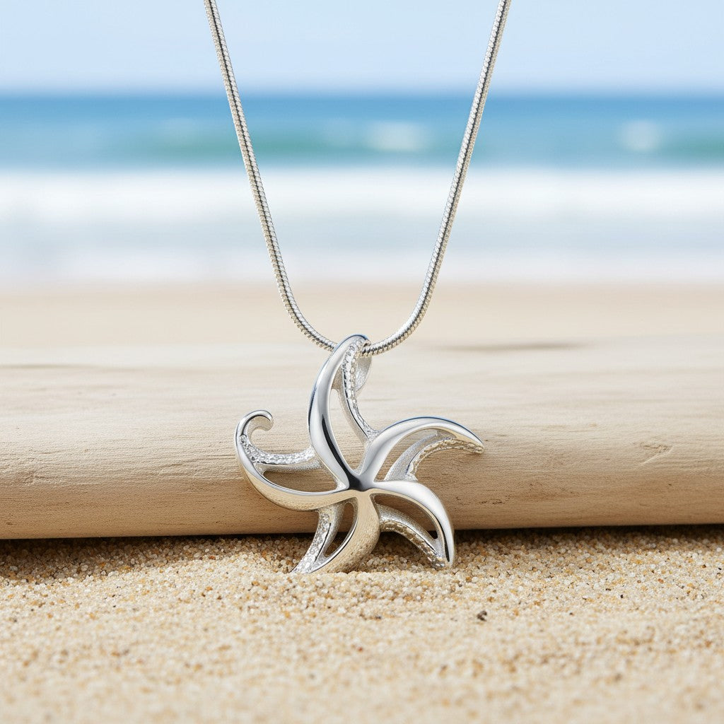 Silver starfish pendant on a chain against a beach background