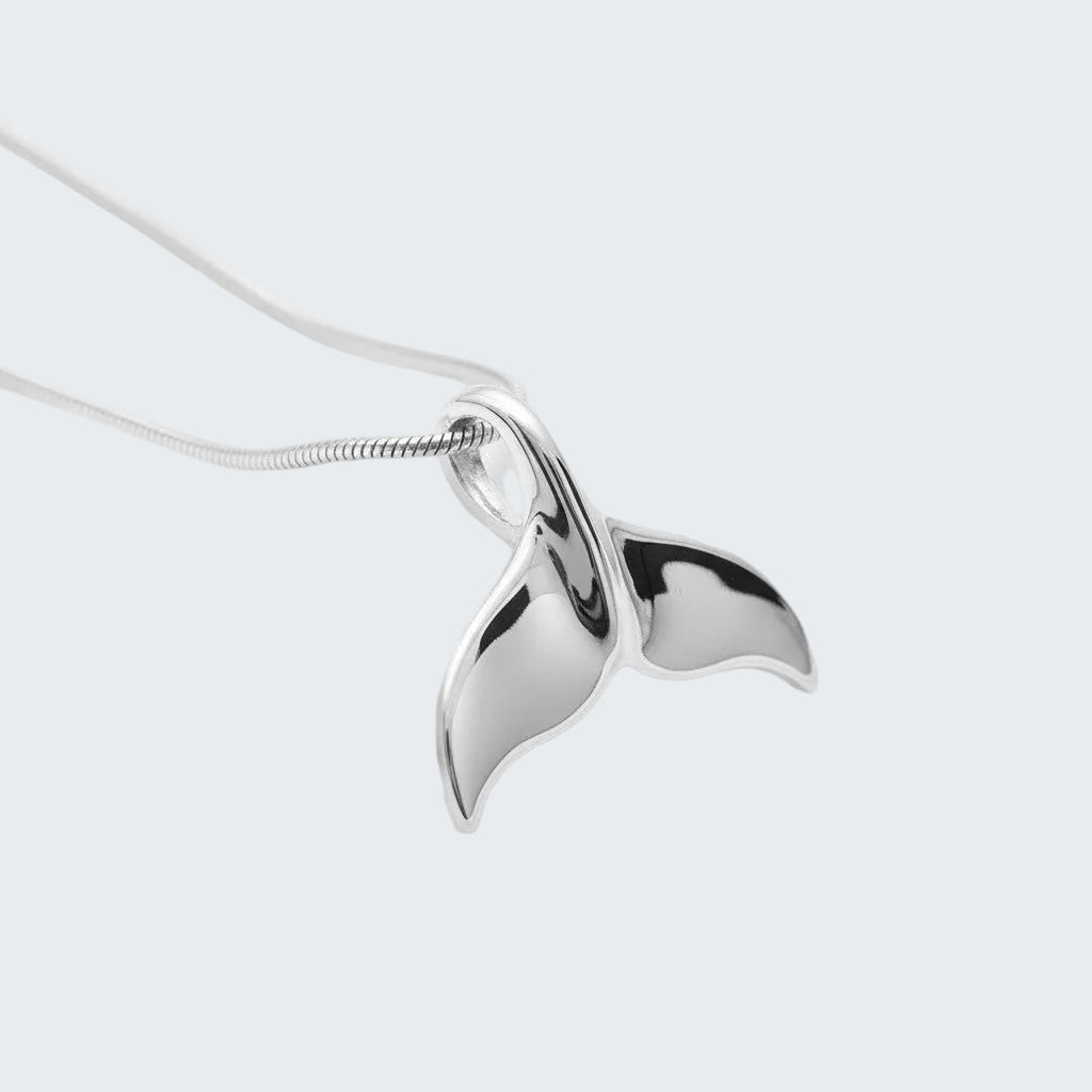 Silver whale tail pendant on a white background