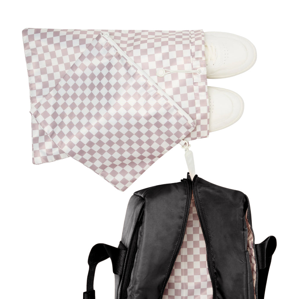 Checkered pillow with white feet on a backpack against a white background