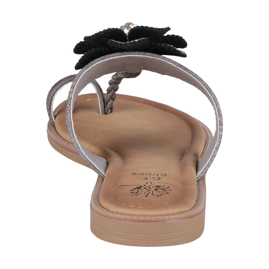 Flip-flop sandal with a black flower design on a white background