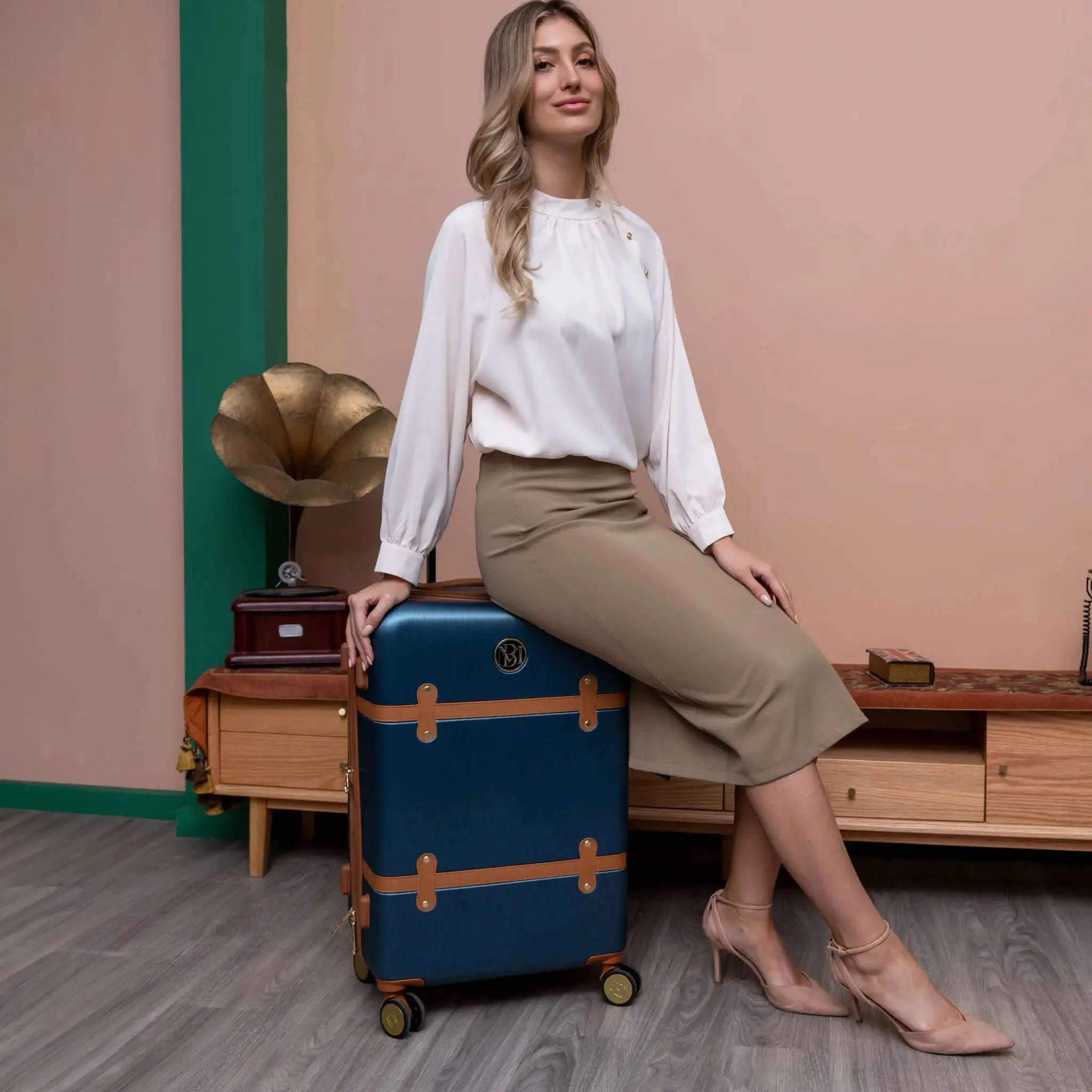 Woman sitting on a vintage suitcase with a gramophone in the background