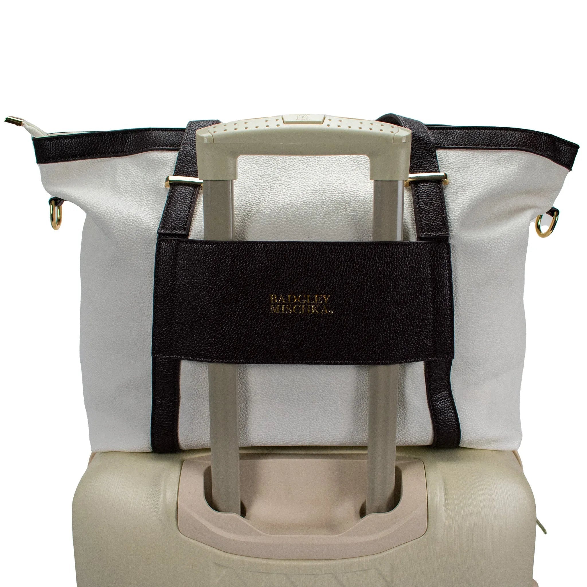 White tote bag with black handle strap on a beige suitcase, featuring the brand 'Bally Mischka'.