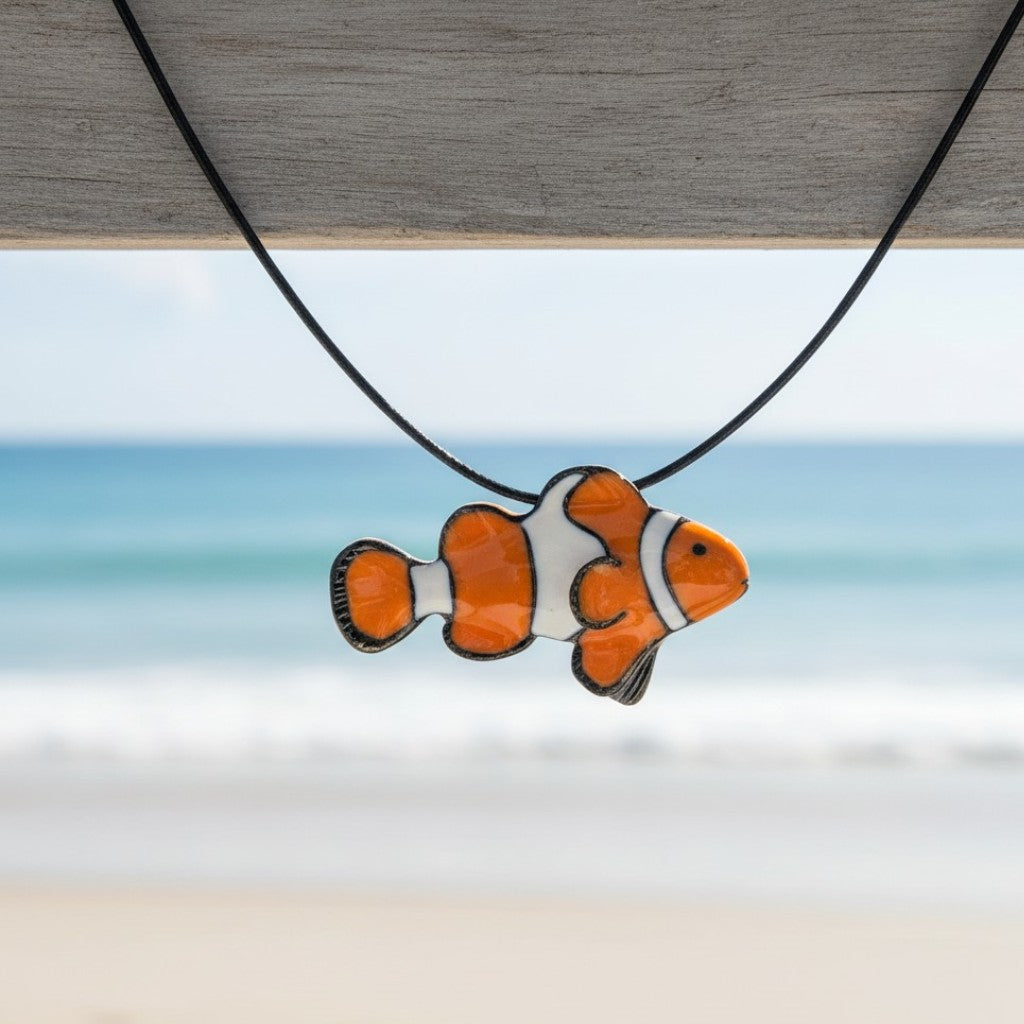 Clownfish pendant on a necklace with a blurred beach background