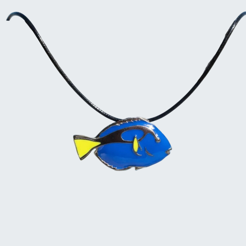 Blue fish-shaped pendant on a black cord against a beach background