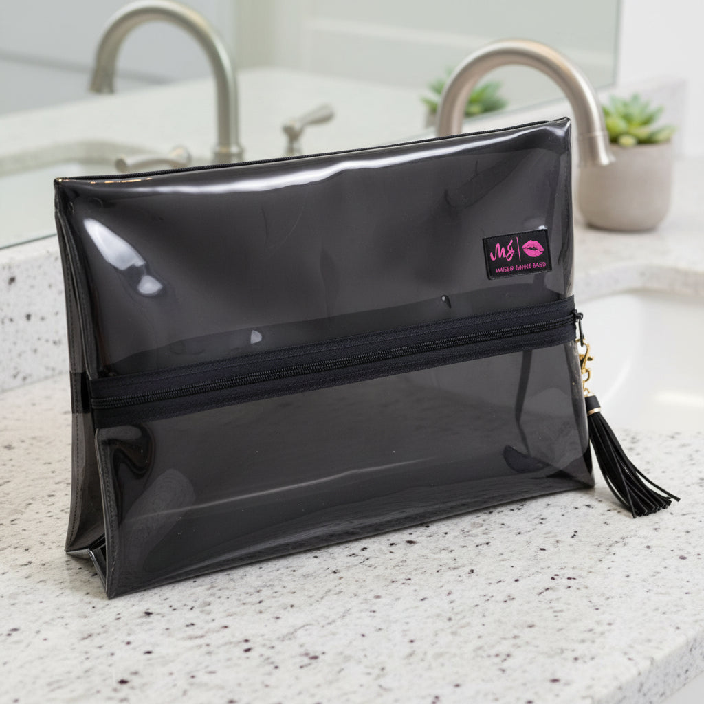Clear makeup bag with black interior and gold zipper, featuring a visible brand logo.