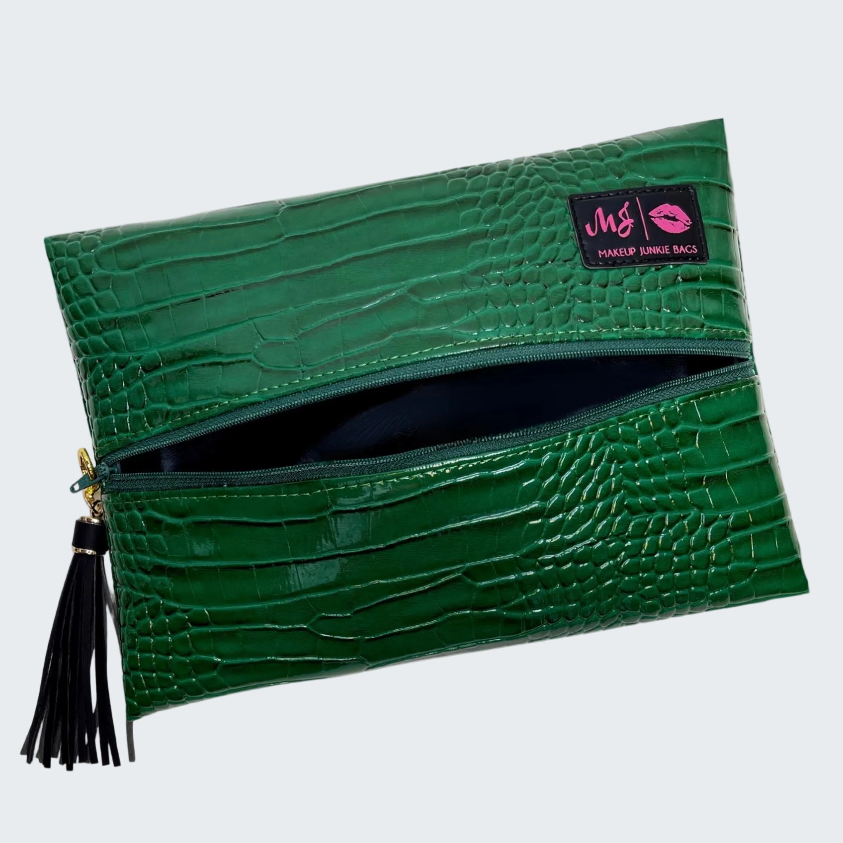 Green crocodile-patterned clutch bag with a visible brand label on a white background