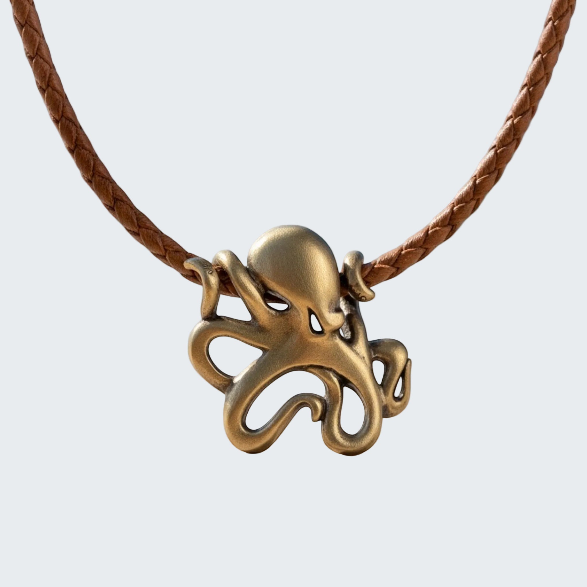 Bronze octopus pendant on a leather cord with a beach background
