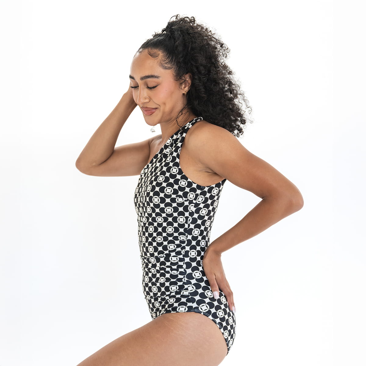 Woman wearing a black and white patterned swimsuit on a white background