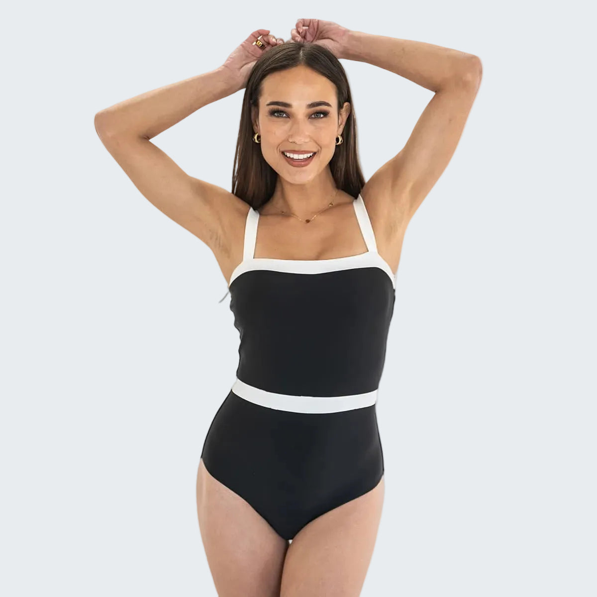 Woman wearing a black and white swimsuit on a white background