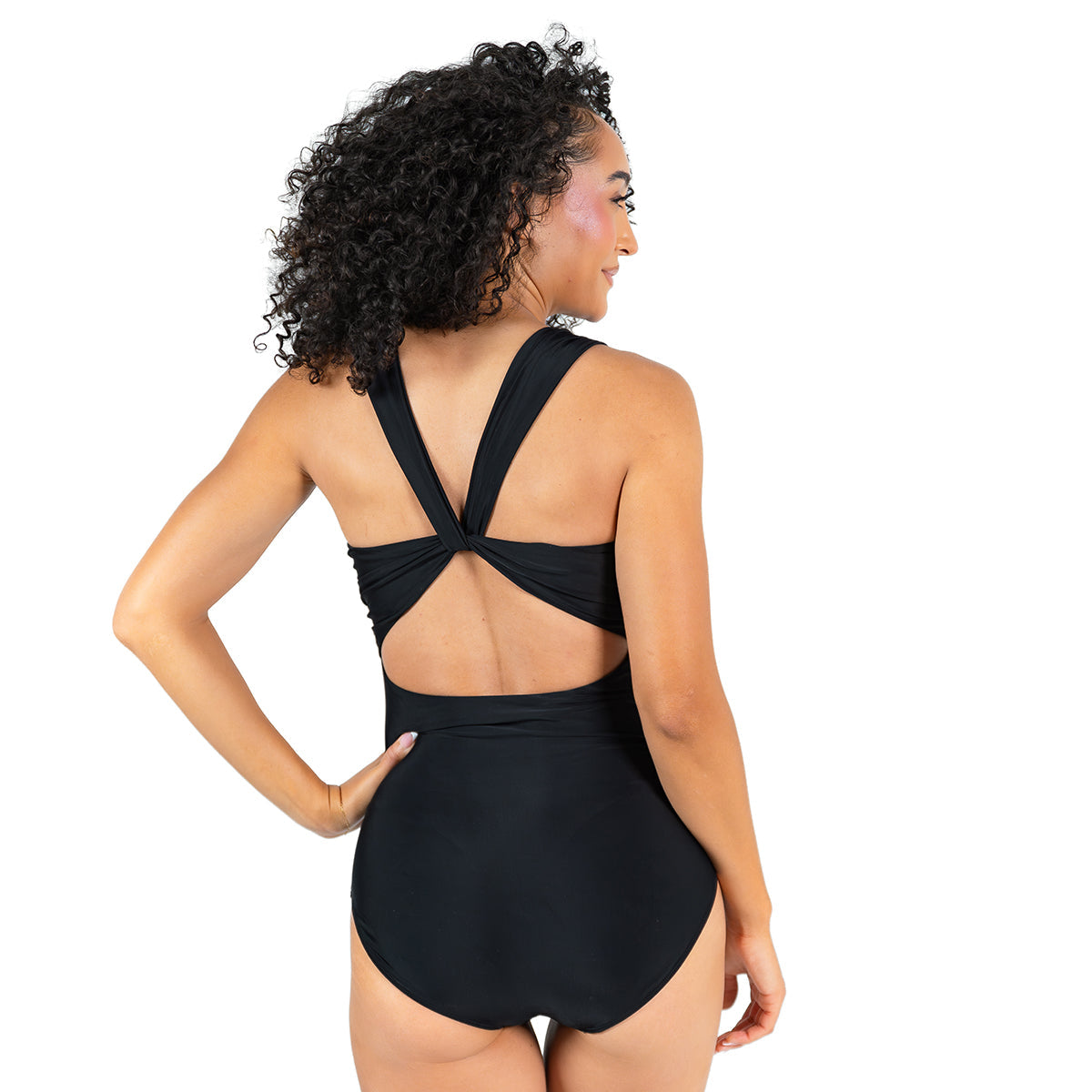 Woman wearing a black swimsuit with a unique back design on a white background