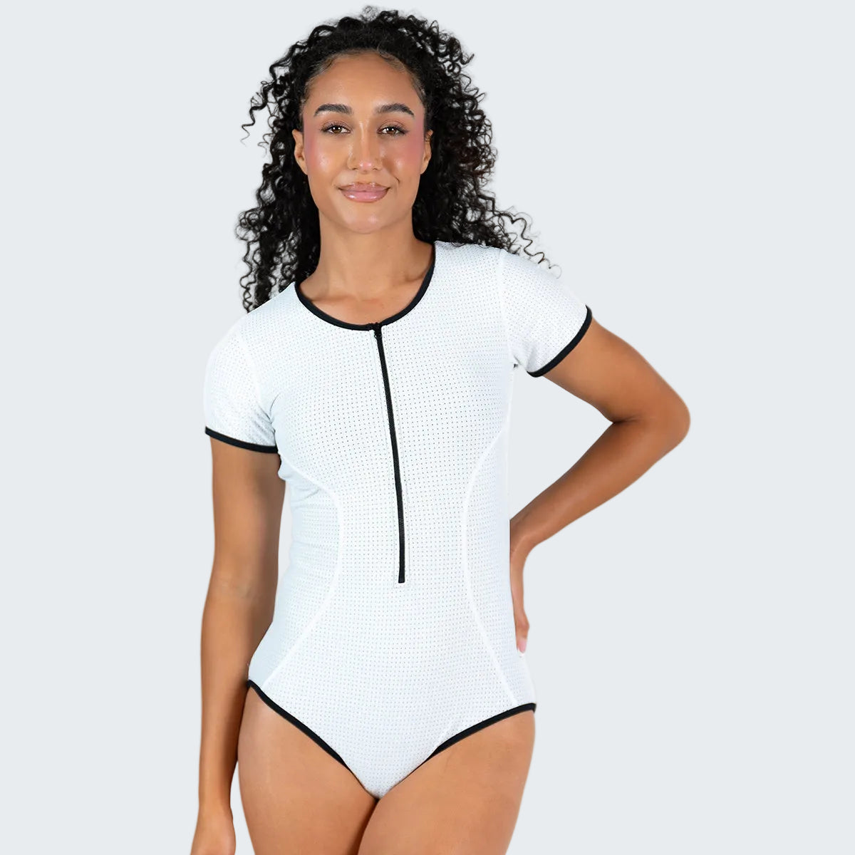Woman wearing a white and black swimsuit on a white background