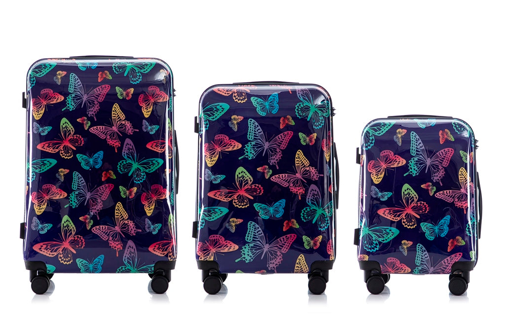 Three suitcases with colorful butterfly pattern on a white background