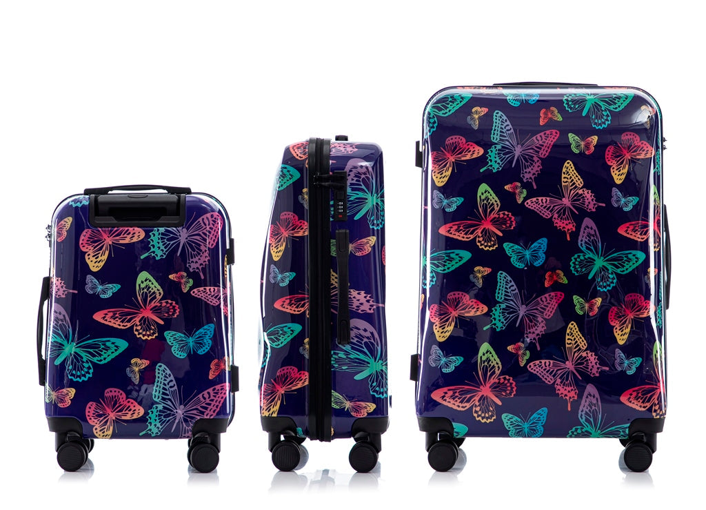 Set of three suitcases with colorful butterfly pattern on a white background