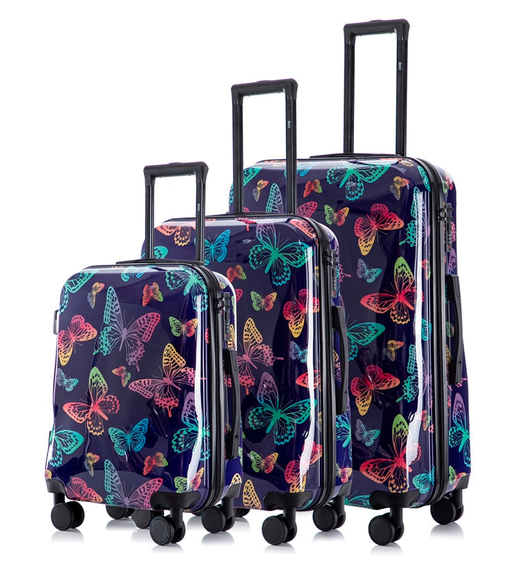 Set of three suitcases with butterfly pattern on a white background