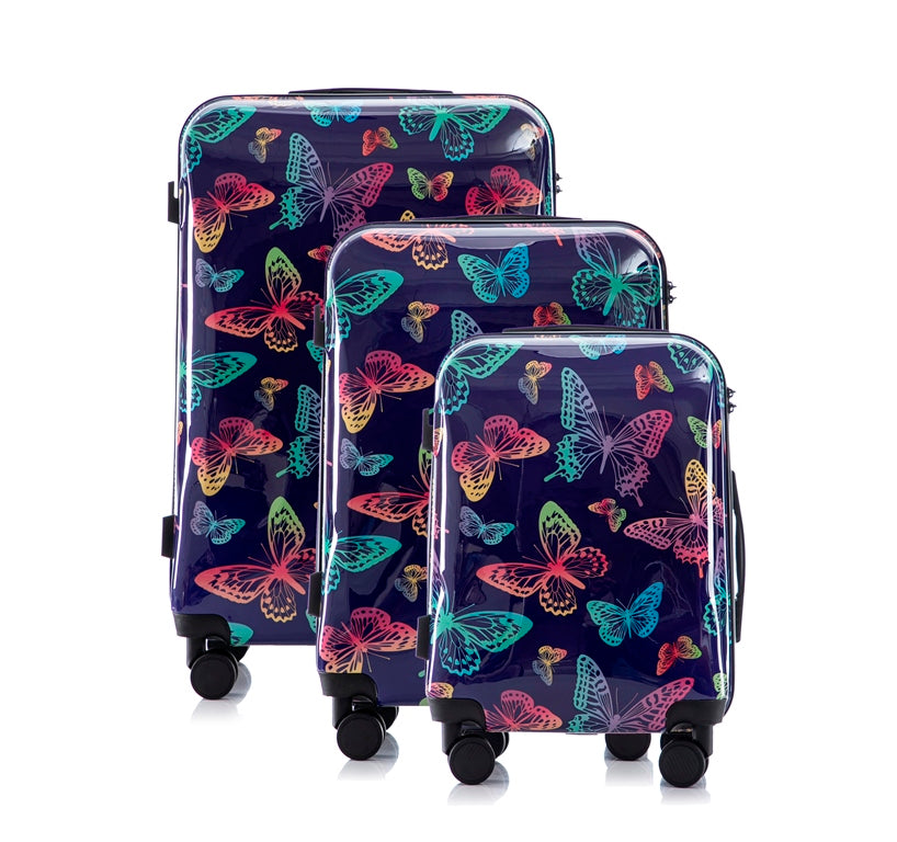Set of three suitcases with colorful butterfly pattern on a white background