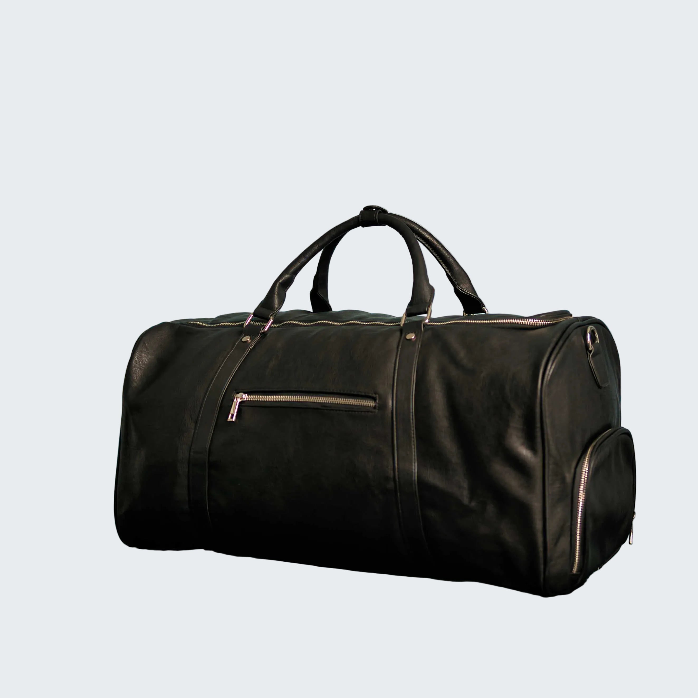 Black duffel bag on a reflective surface with a decorative blue wall in the background