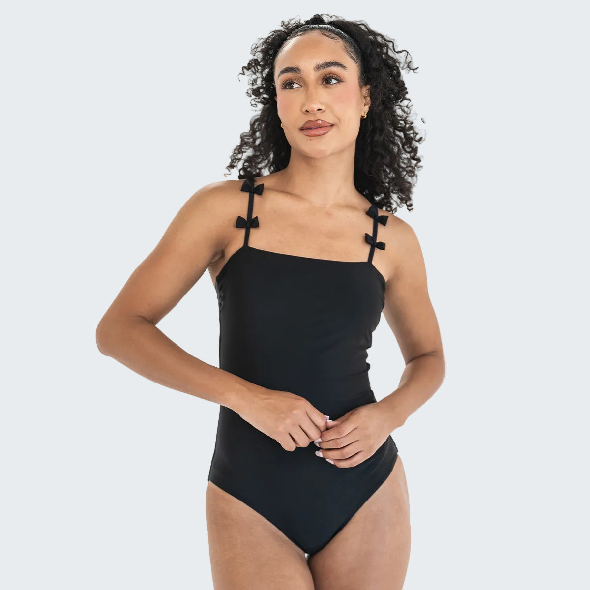 Woman wearing a black one-piece swimsuit on a white background