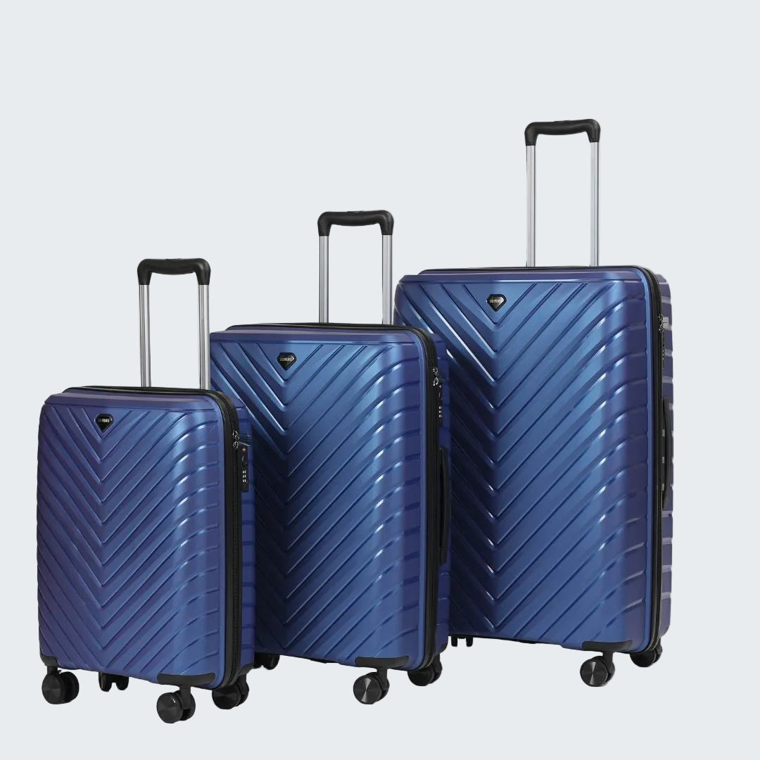 Set of three blue suitcases with chevron pattern on a light gray background